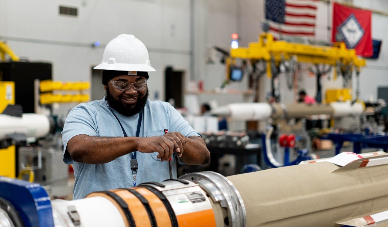 Assembler wearing hard hat in production area working