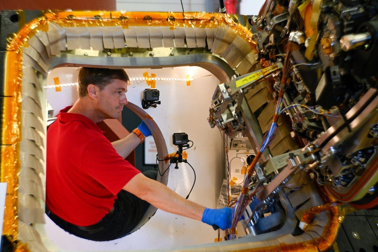 Artemis II astronaut Reid Wiseman inspects and tests the Orion hatch during testing at Lockheed Martin in Littleton, CO