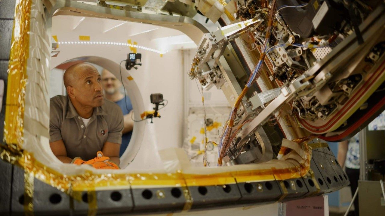 Artemis II astronaut Victor Glover inspecting the Orion hatch during life-cycle testing at Lockheed Martin